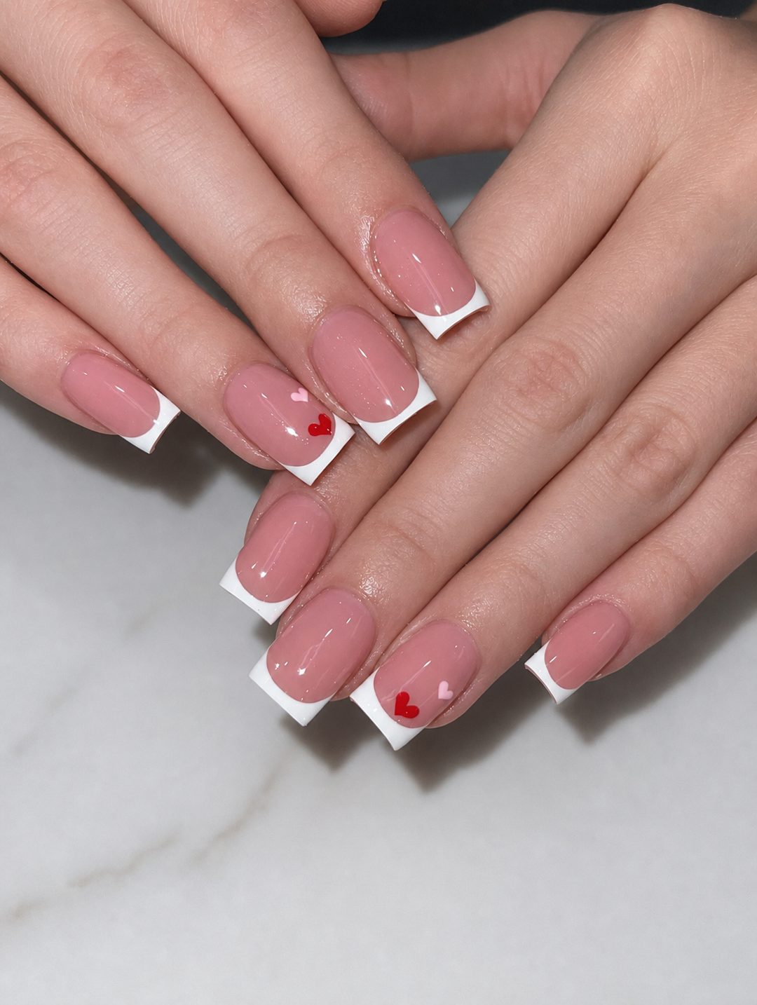 Clean white French manicure with delicate heart details